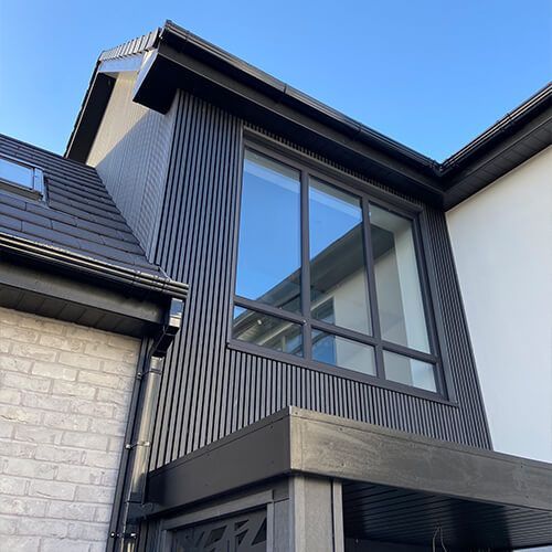 Close-up of grey composite decking boards with dark garden railing